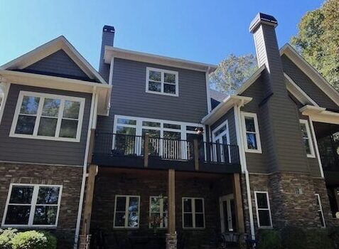 Completed home exterior featuring James Hardie Timber Bark siding, Arctic White trim, second-story dormer windows, and a two-car garage after C&W's siding renovation.