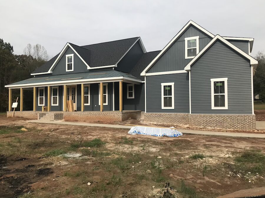 Pickens, SC home exterior with dark vinyl siding, board and batten accents, white windows, and asphalt shingle roofing